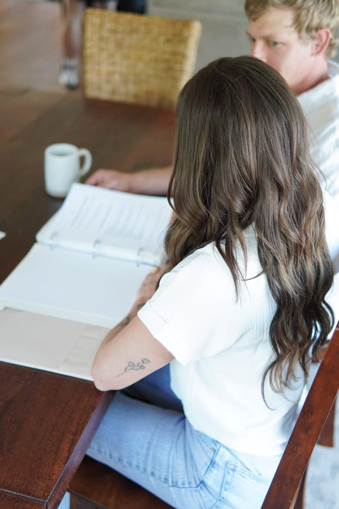Newlywed organizing marriage certificate and name change paperwork with a checklist on a desk.