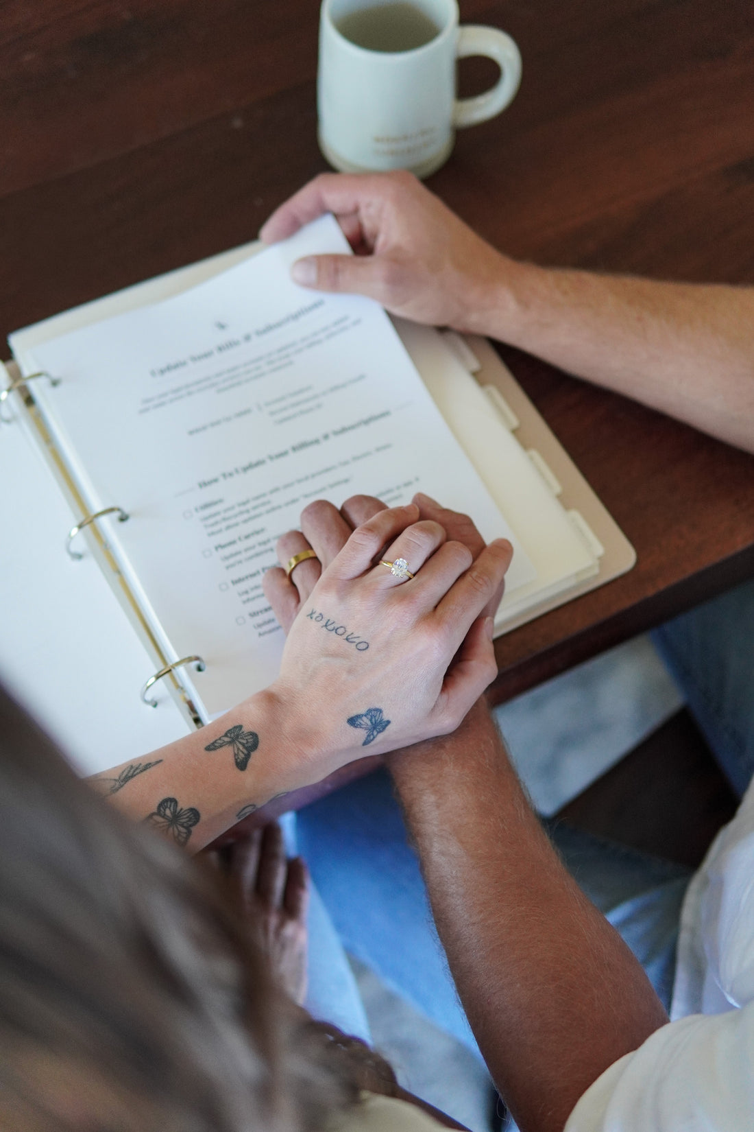 Newlywed couple organizing marriage documents, insurance papers, and important records in a keepsake binder.