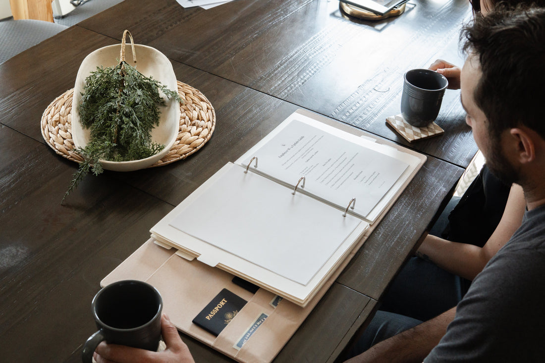 married couple organizing important documents, including their marriage certificate, insurance policies, tax records, and estate planning paperwork in a home filing system.