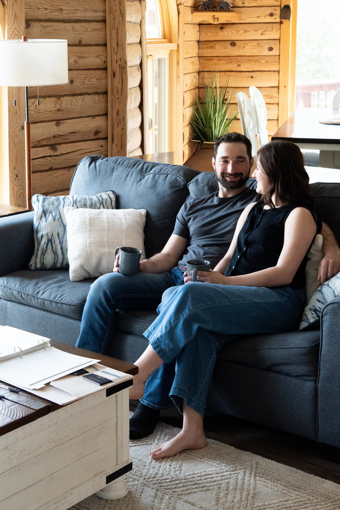 A married couple organizing important documents, including insurance papers, tax records, and their marriage certificate, into one home filing system.